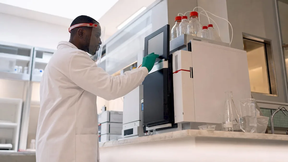 Technician operating chromatography equipment in lab
